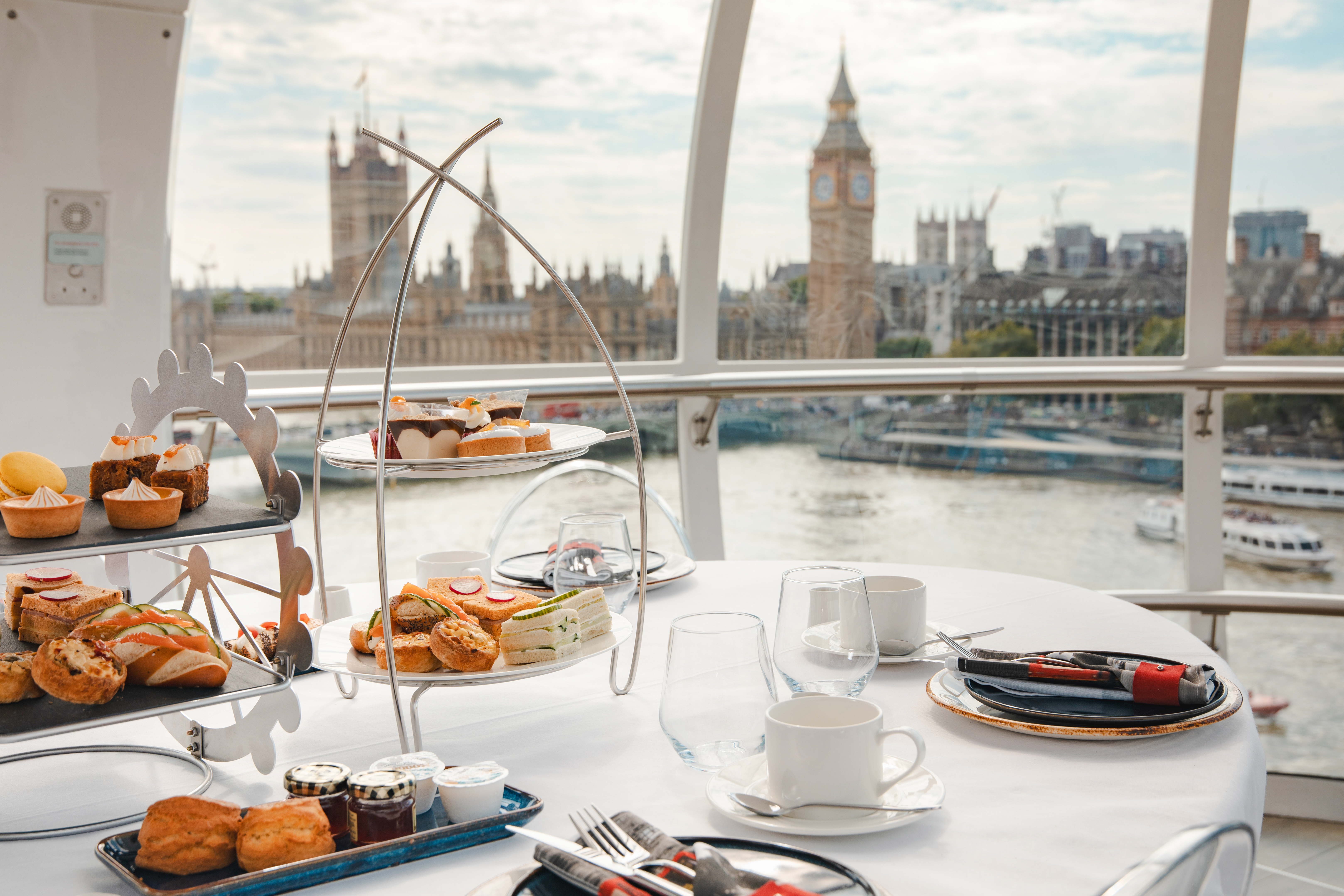 Afternoon tea setup inside the London Eye with views of Big Ben and the Thames.