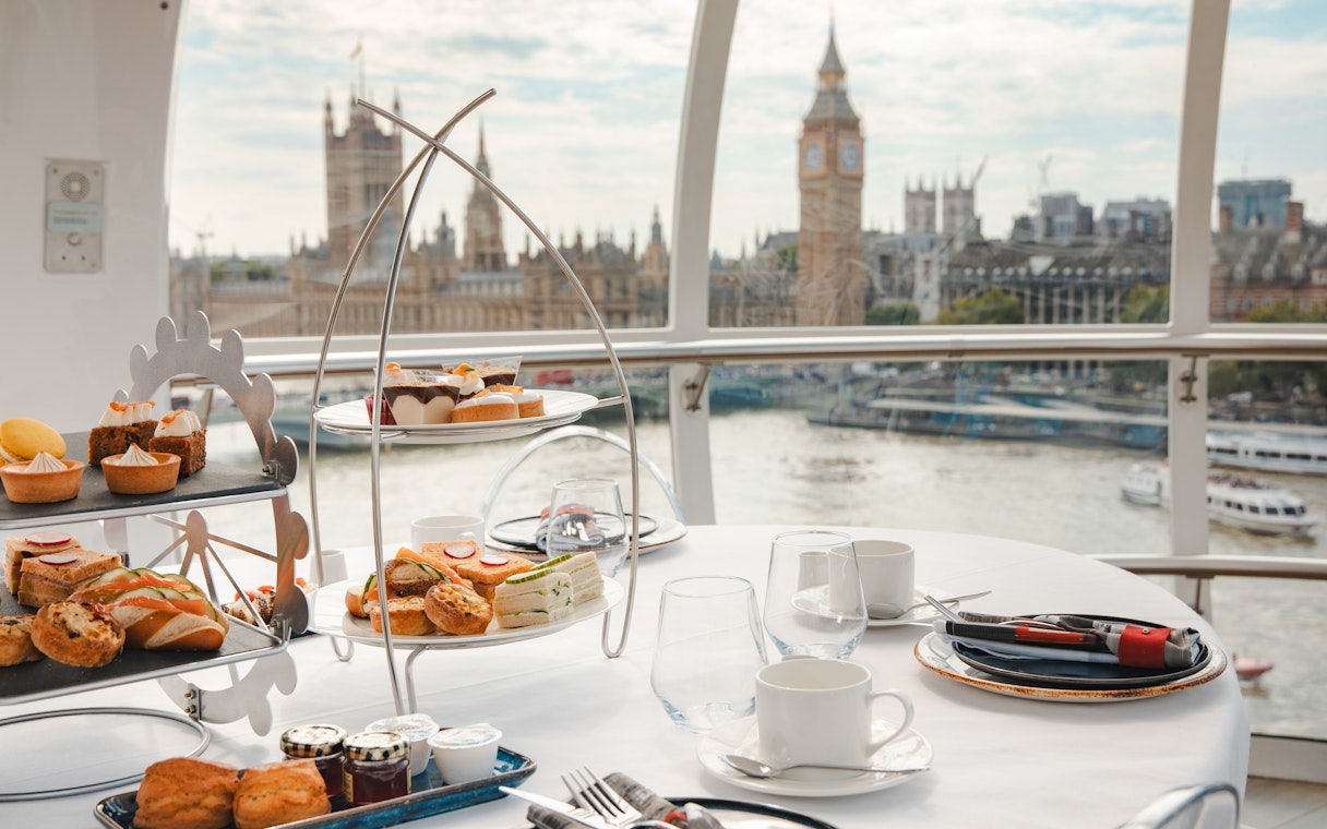 Afternoon tea setup inside the London Eye with views of Big Ben and the Thames.