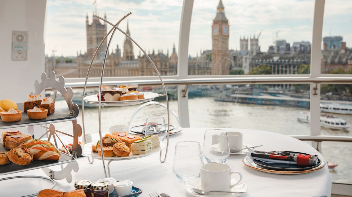 Afternoon tea setup inside the London Eye with views of Big Ben and the Thames.