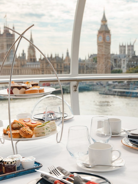 Afternoon tea setup inside the London Eye with views of Big Ben and the Thames.