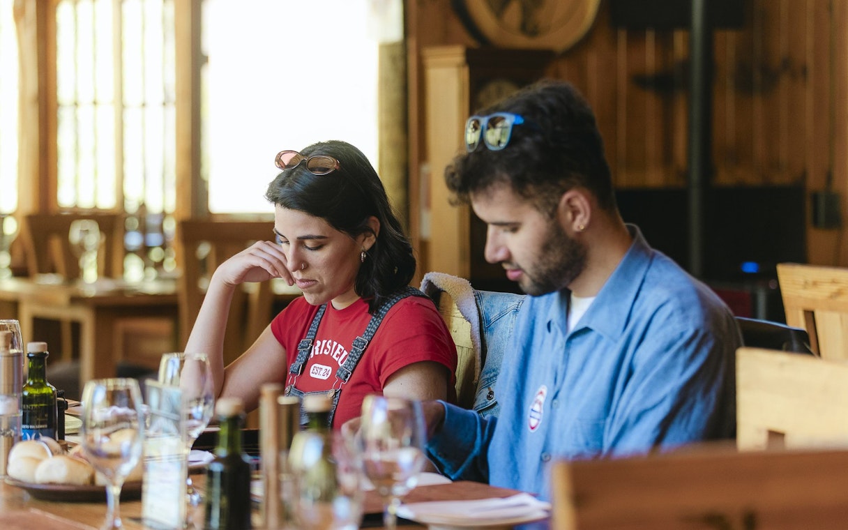 Tourists reviewing menu at Santuario del Río spa and lodge dining area.