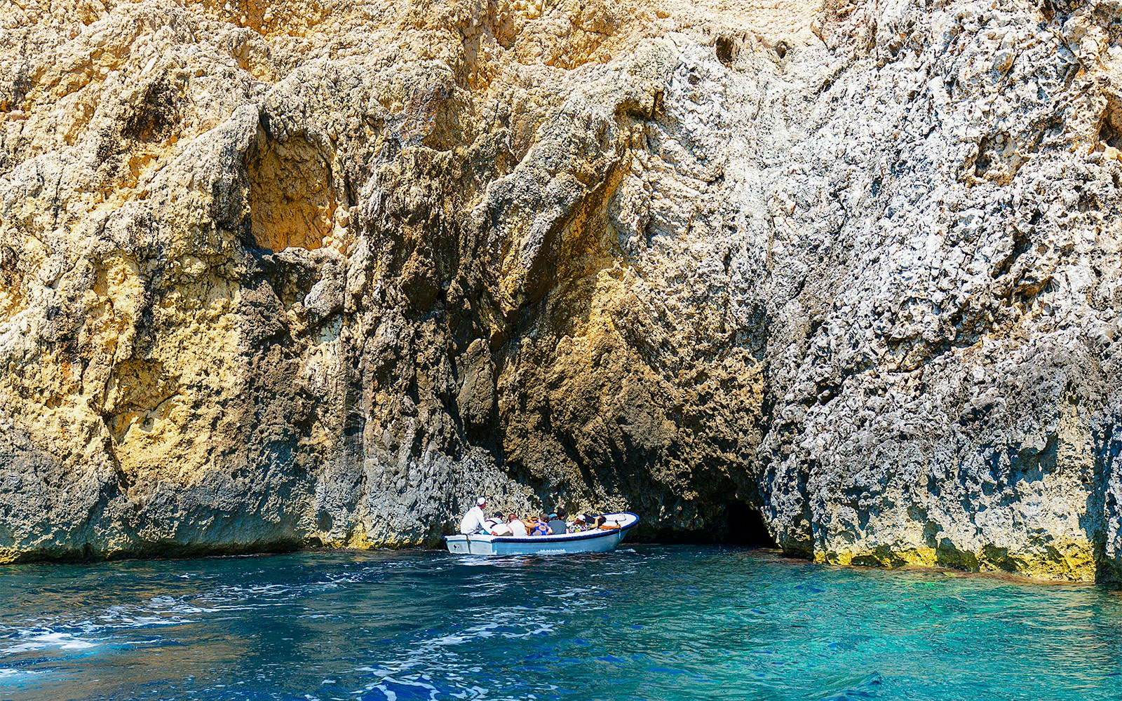 Boat entering Blue Cave on Adriatic Sea, Croatia.