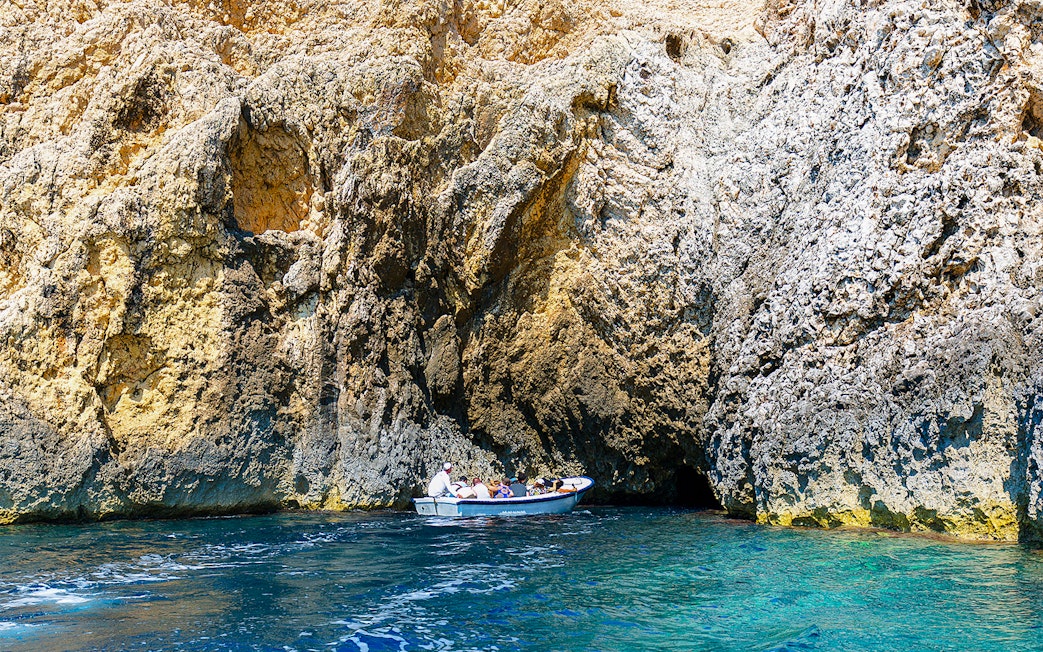 Boat entering Blue Cave on Adriatic Sea, Croatia.