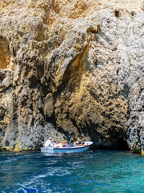 Boat entering Blue Cave on Adriatic Sea, Croatia.