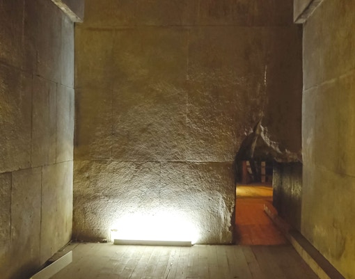 Interior passageway of the Pyramid of Menkaure, Giza, with stone walls and dim lighting.