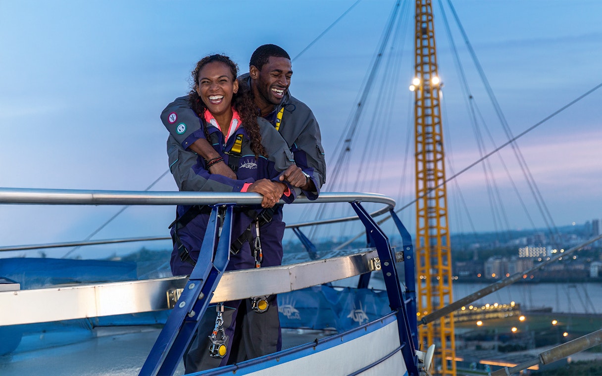 Guests enjoying the view from the O2 rooftop at twilight in London.