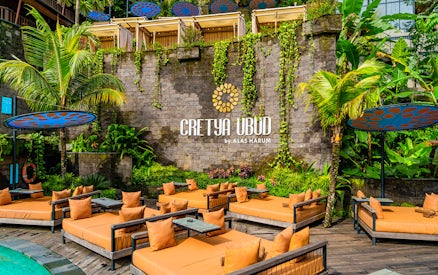 Poolside lounge area at Cretya Spa, Alas Harum Bali, with sunbeds and tropical plants.