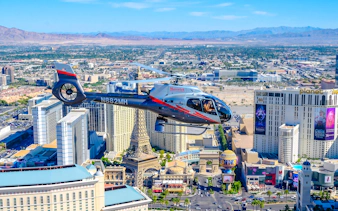 Helicopter flying over Las Vegas Strip with view of Paris Las Vegas and surrounding hotels.