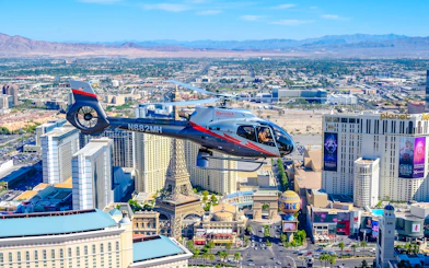 Helicopter flying over Las Vegas Strip with view of Paris Las Vegas and surrounding hotels.