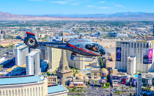 Helicopter flying over Las Vegas Strip with view of Paris Las Vegas and surrounding hotels.