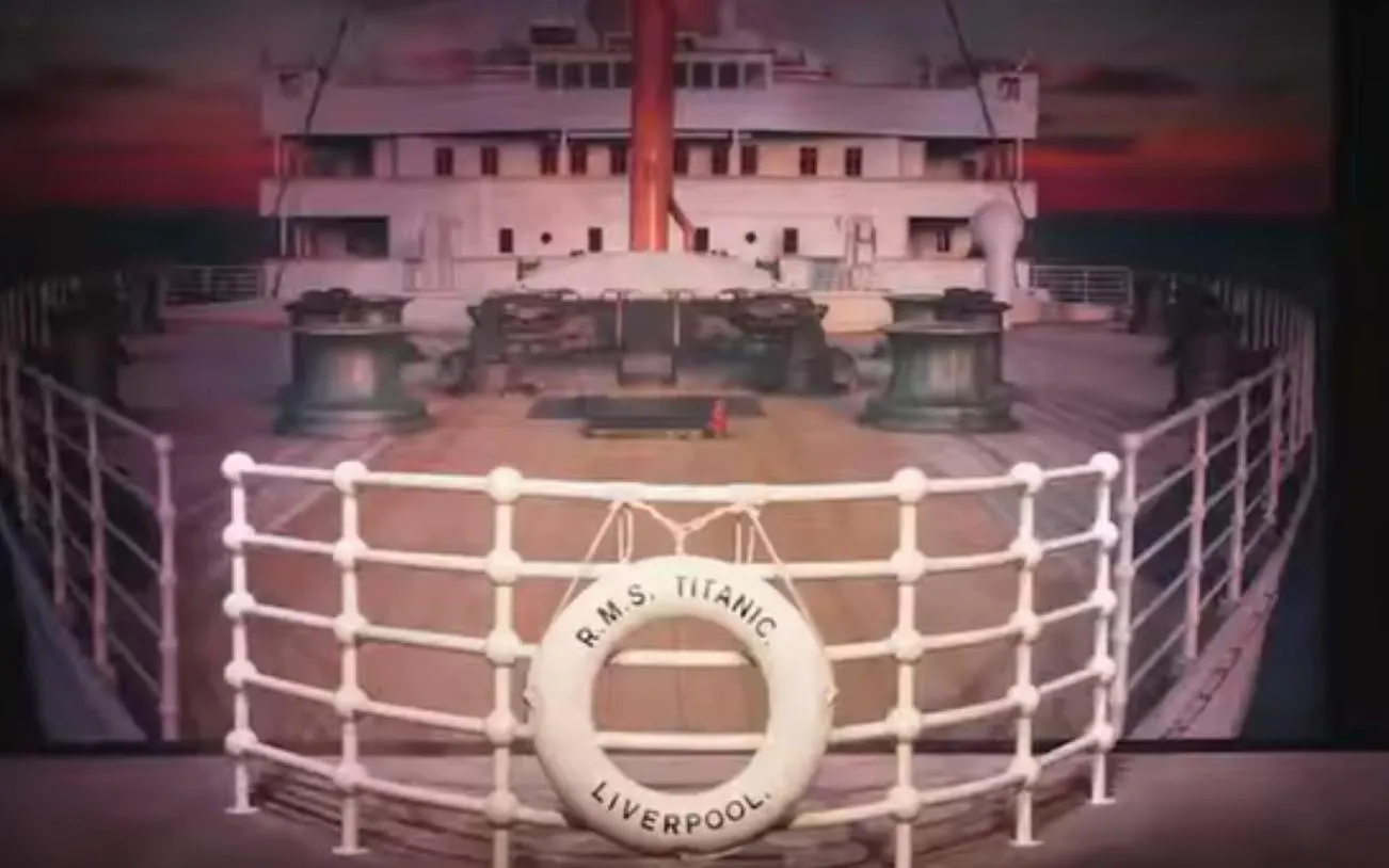 Titanic ship deck with lifebuoy labeled "R.M.S. Titanic Liverpool" at sunset, Houston exhibit.