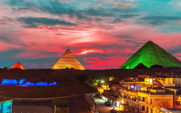 Great Pyramid complex illuminated at night, Giza, Egypt.