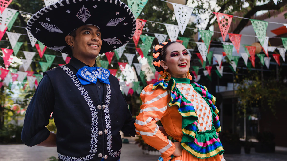 Traditional dancers in colorful attire celebrating Cinco de Mayo with festive banners.
