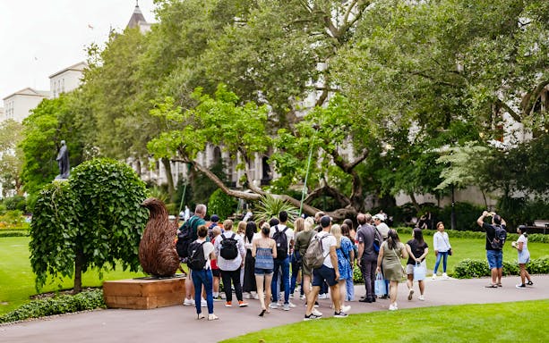 Group of tourists on a Harry Potter London film locations tour in a park setting.