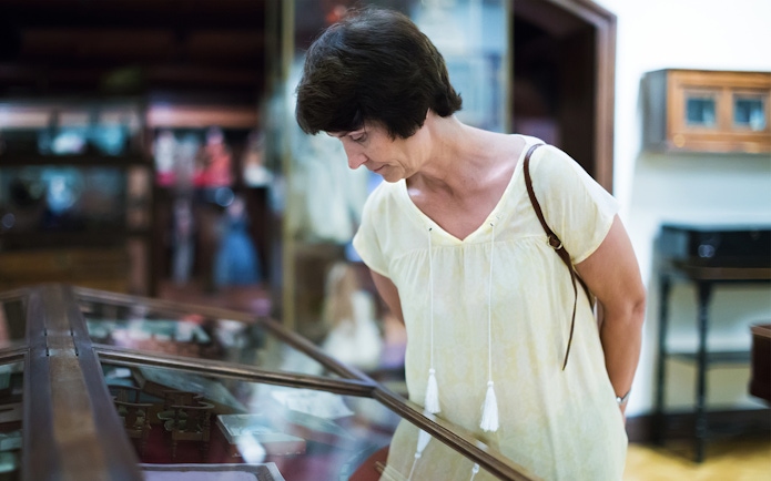 Visitor examining display case at the National Prague Museum.