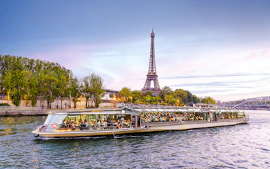 Bateaux Parisiens cruise on Seine River with Eiffel Tower in background, Paris, France.