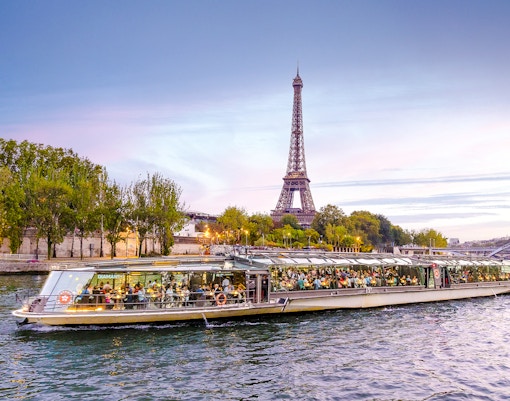Bateaux Parisiens cruise on Seine River with Eiffel Tower in background, Paris, France.