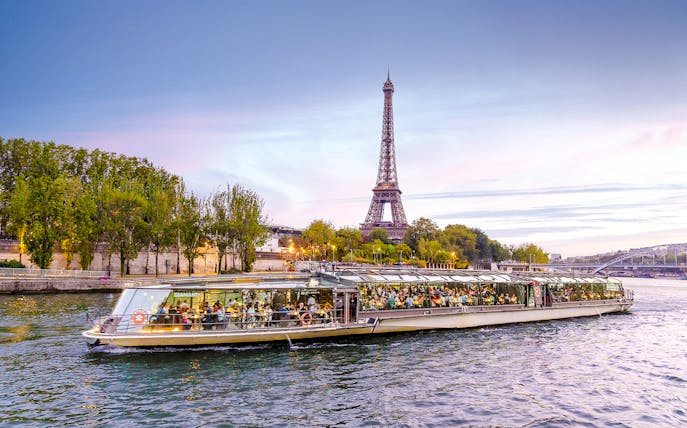 Bateaux Parisiens cruise on Seine River with Eiffel Tower in background, Paris, France.