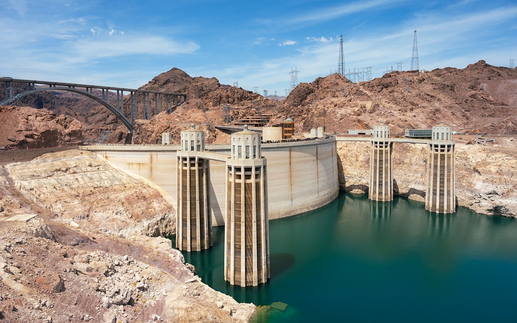 Hoover Dam with surrounding rocky landscape and bridge in Nevada.