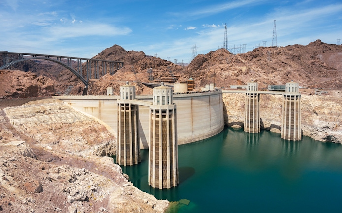 Hoover Dam with surrounding rocky landscape and bridge in Nevada.