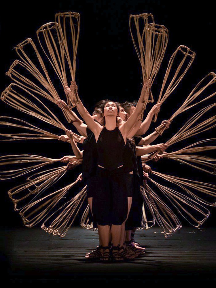 Performers holding baskets in formation at A O Show circus, Vietnam.