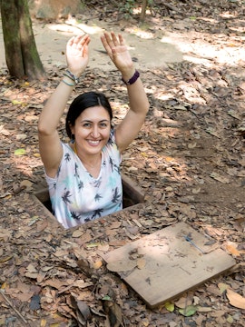 Person emerging from Cu Chi Tunnel entrance in Vietnam.