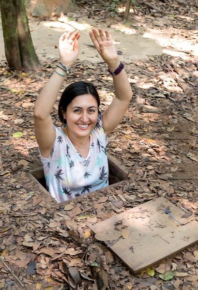Person emerging from Cu Chi Tunnel entrance in Vietnam.
