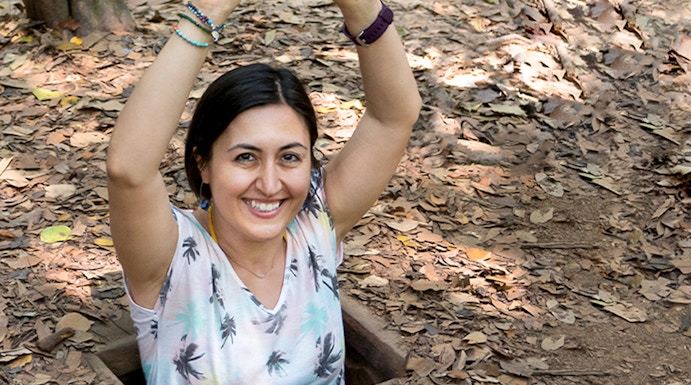 Person emerging from Cu Chi Tunnel entrance in Vietnam.
