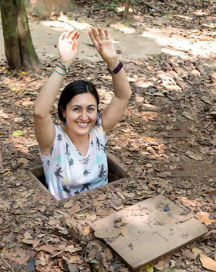 Person emerging from Cu Chi Tunnel entrance in Vietnam.