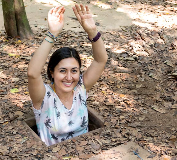 Person emerging from Cu Chi Tunnel entrance in Vietnam.