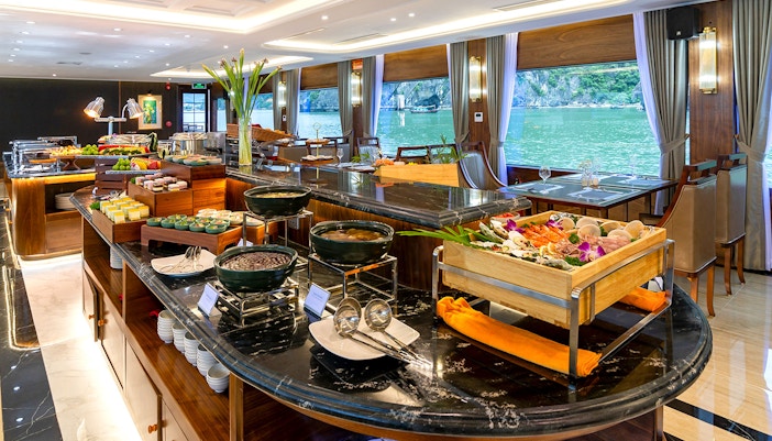 Luxurious dining area with buffet on Ha Long Bay 5-Star Cruise, featuring seafood and scenic views.