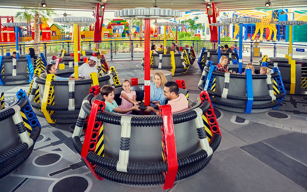 Children on the Disc-O-Saucers ride at Legoland Dubai, enjoying a family attraction.