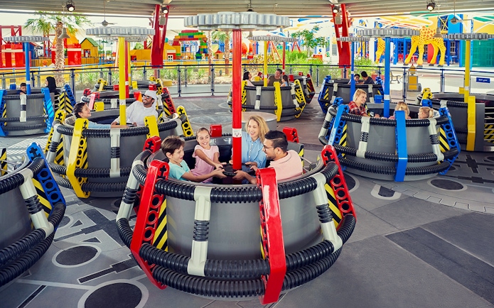 Children on the Disc-O-Saucers ride at Legoland Dubai, enjoying a family attraction.
