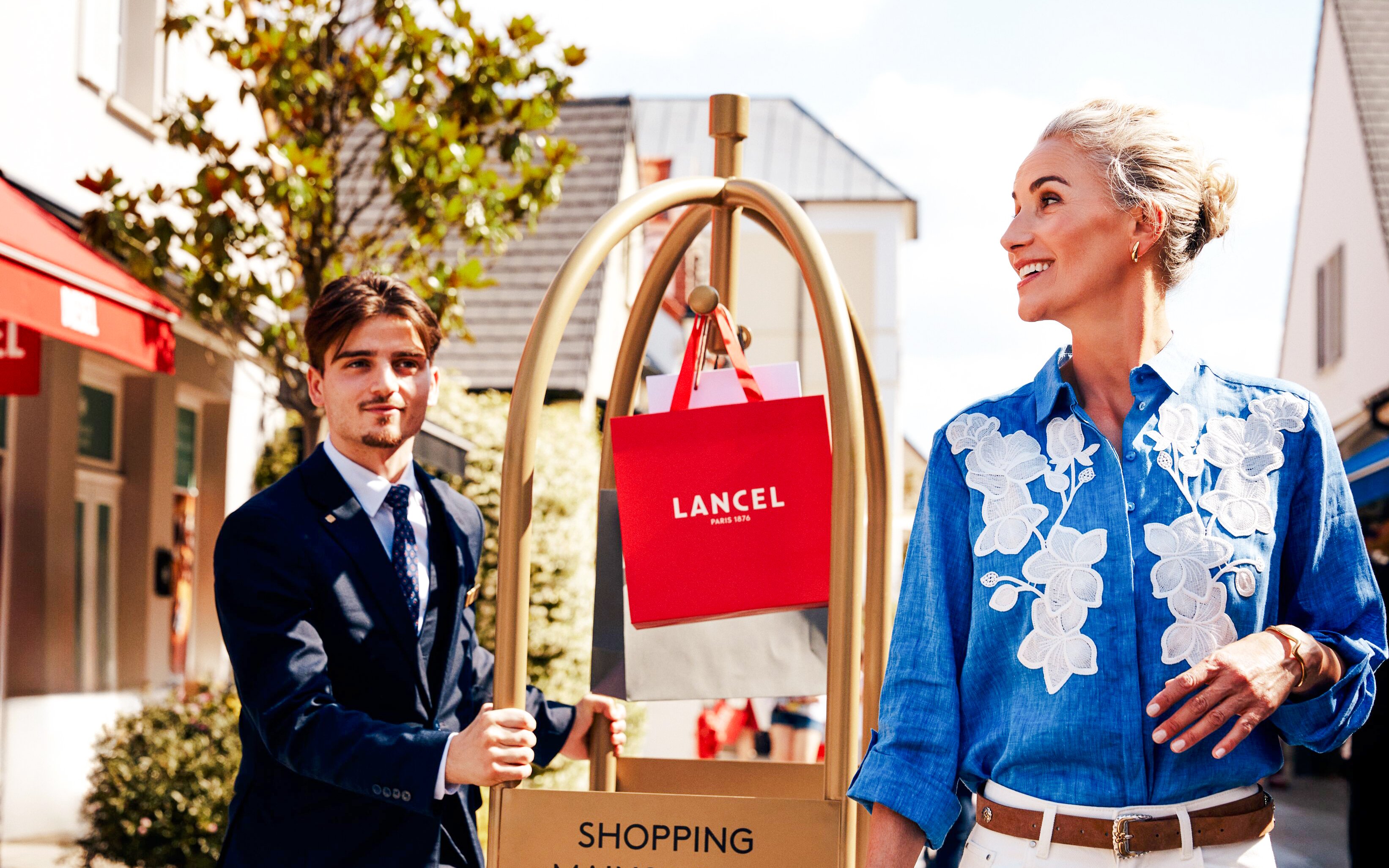 Shopping at La Vallee Village, Paris with Lancel bags on a cart.