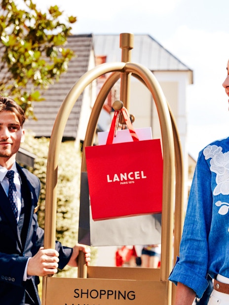 Shopping at La Vallee Village, Paris with Lancel bags on a cart.