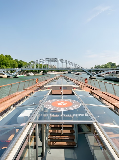 Seine River cruise boat approaching a bridge in Paris, France.