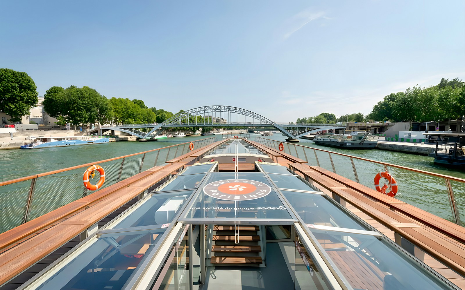 Seine River cruise boat approaching a bridge in Paris, France.