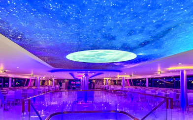 Luxury White Cruise ship interior with starry ceiling and elegant seating.