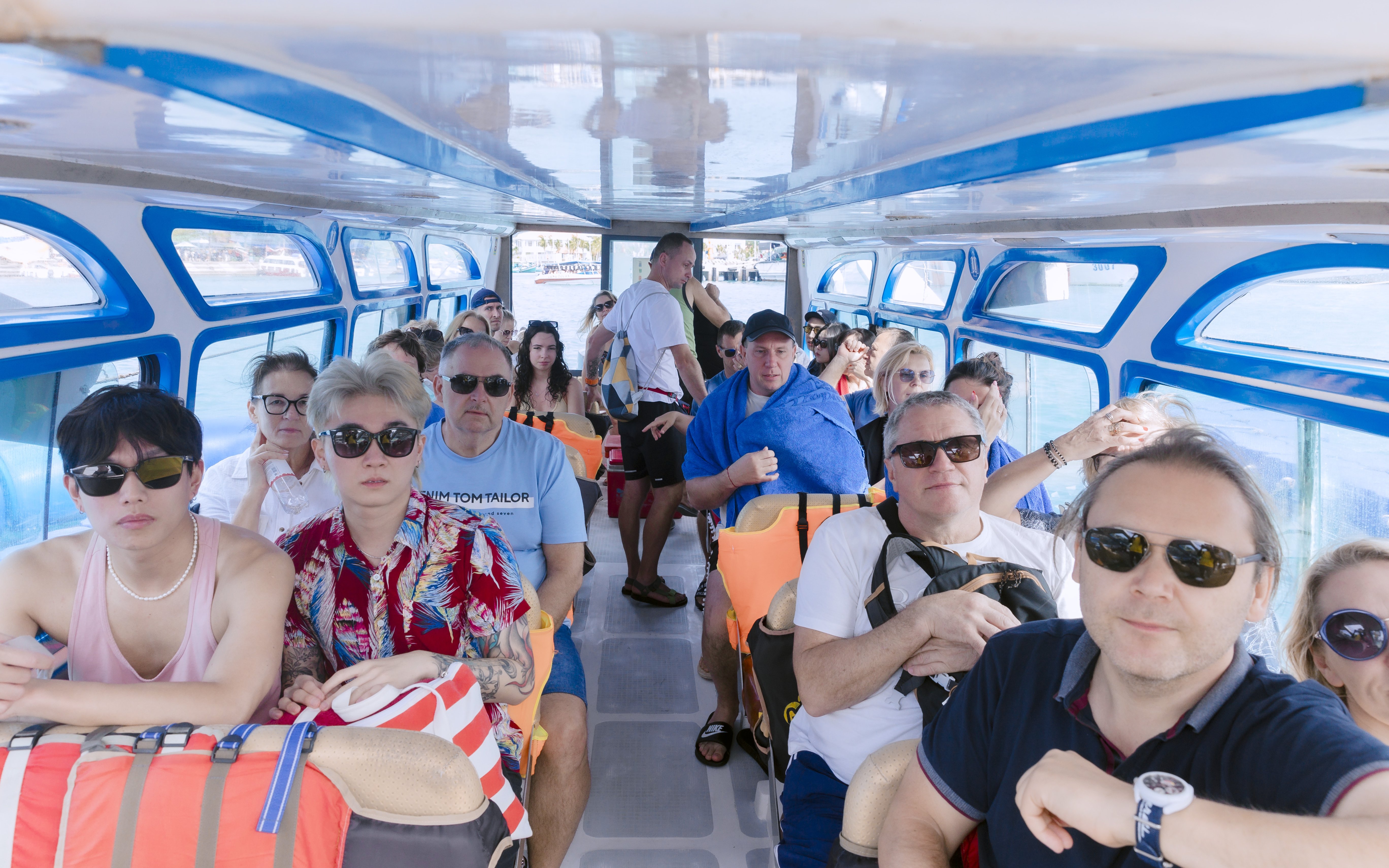 Tourists seated inside a speed boat for a four island day trip.
