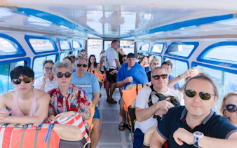 Tourists seated inside a speed boat for a four island day trip.