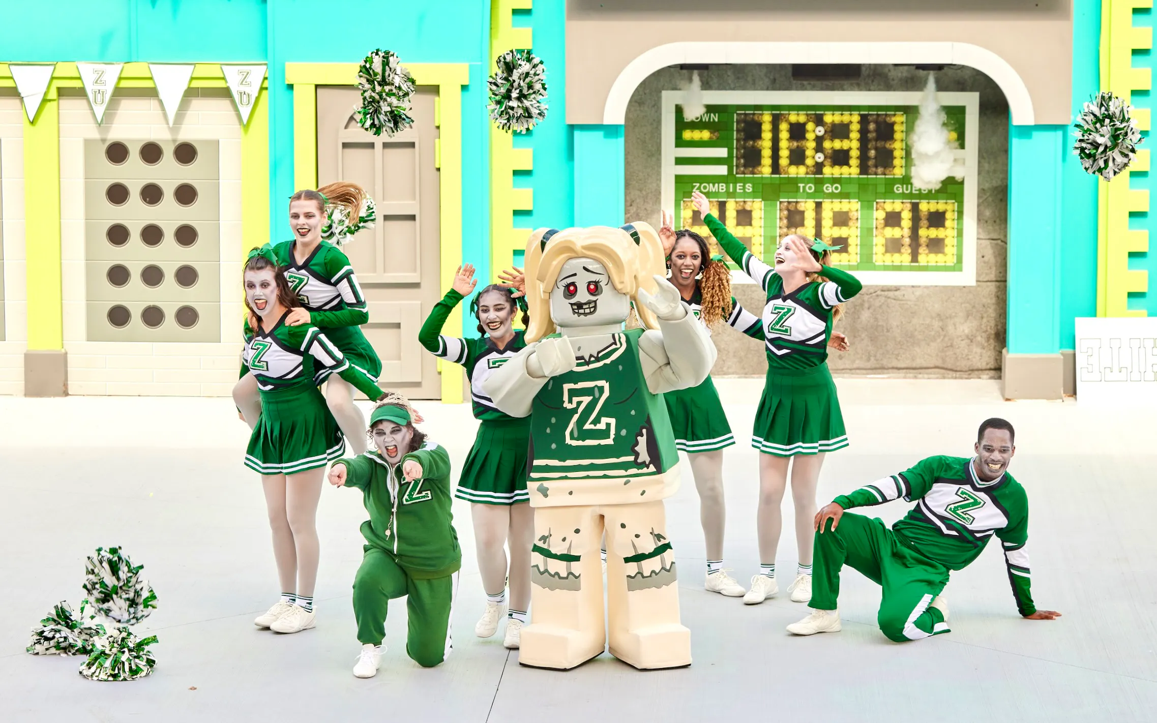 Cheerleaders and a zombie-themed Lego character at Legoland New York Halloween event.