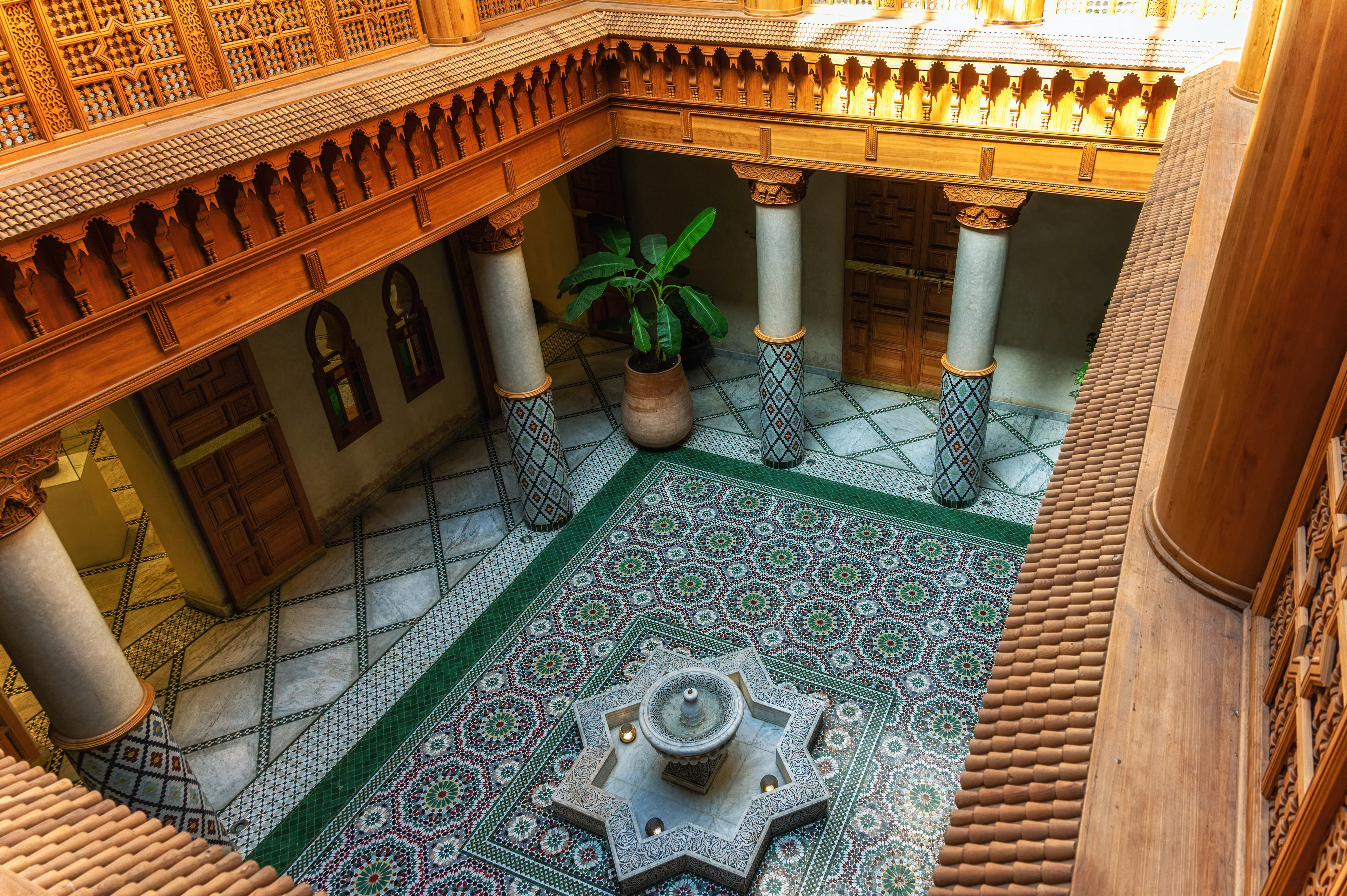Moroccan Culinary Arts Museum interior with ornate tiles and central fountain.