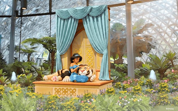 Jasmine with Rajah in a garden setting at a themed attraction.