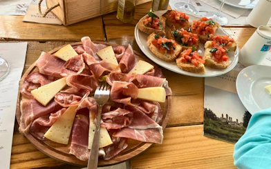 Tuscan charcuterie and bruschetta on a wooden table during a San Gimignano food and wine tour.