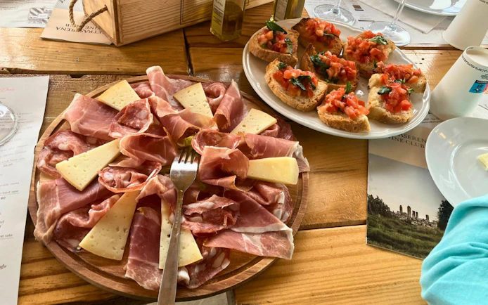 Tuscan charcuterie and bruschetta on a wooden table during a San Gimignano food and wine tour.