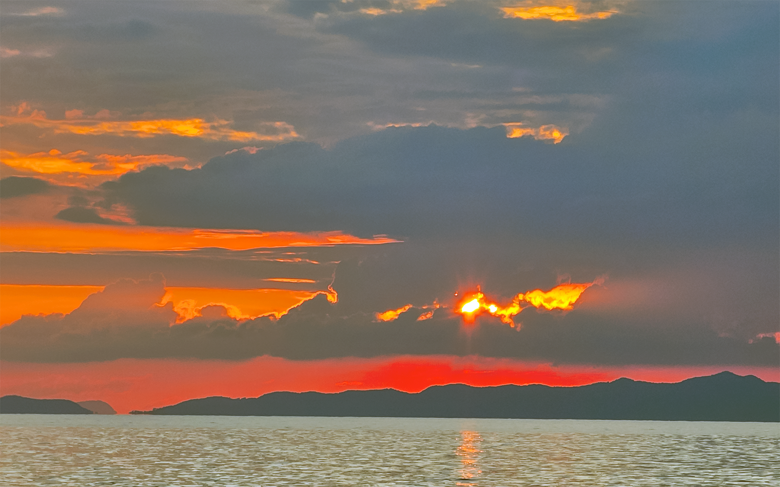 Sunset over the ocean with silhouetted islands in Krabi, Thailand.