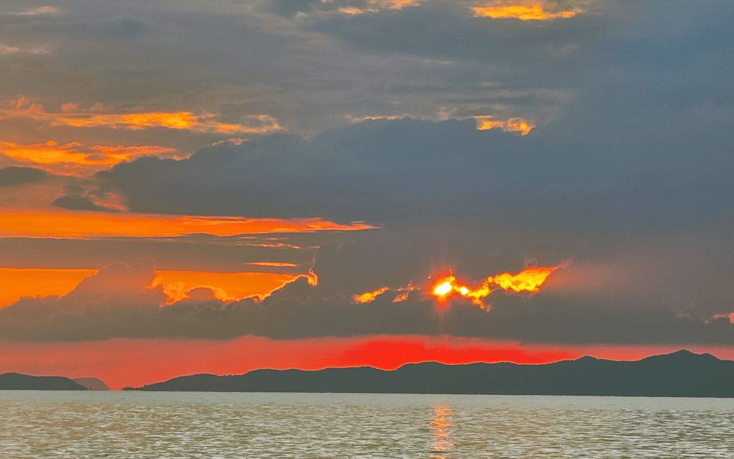 Sunset over the ocean with silhouetted islands in Krabi, Thailand.