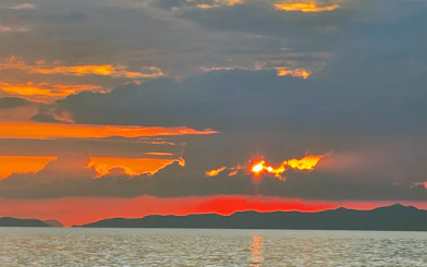 Sunset over the ocean with silhouetted islands in Krabi, Thailand.