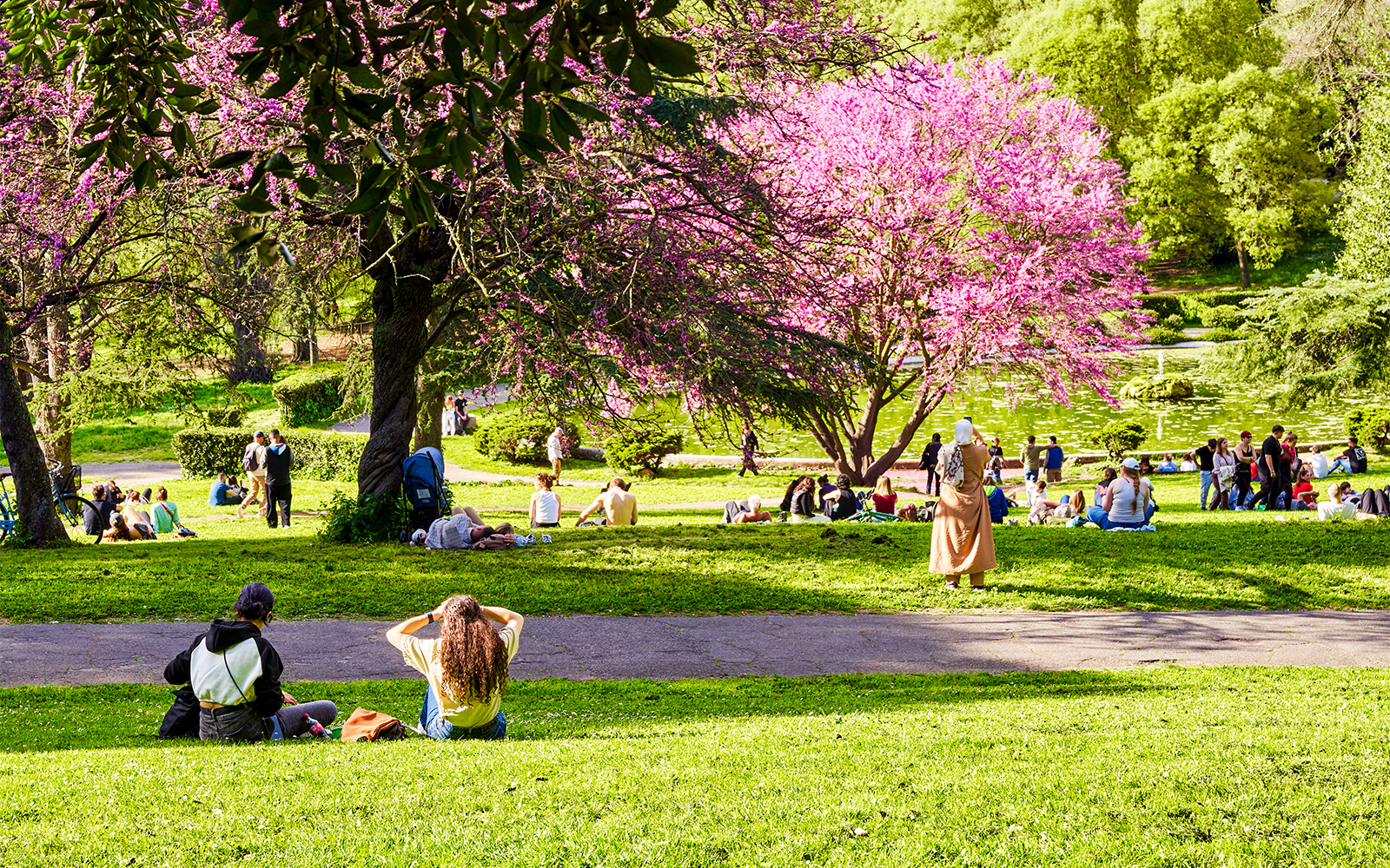 Spring visitors relaxing near Fontana Rotonda in Villa Borghese gardens, Rome, Italy.