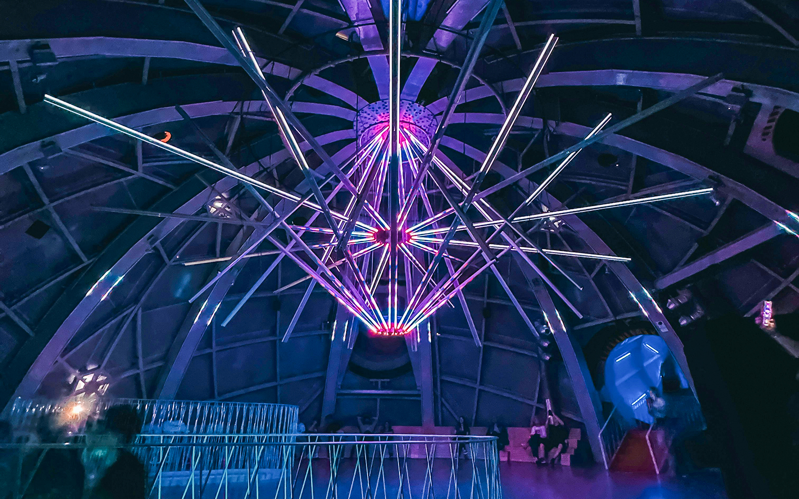 Illuminated interior structure of the Atomium in Brussels with colorful lights.
